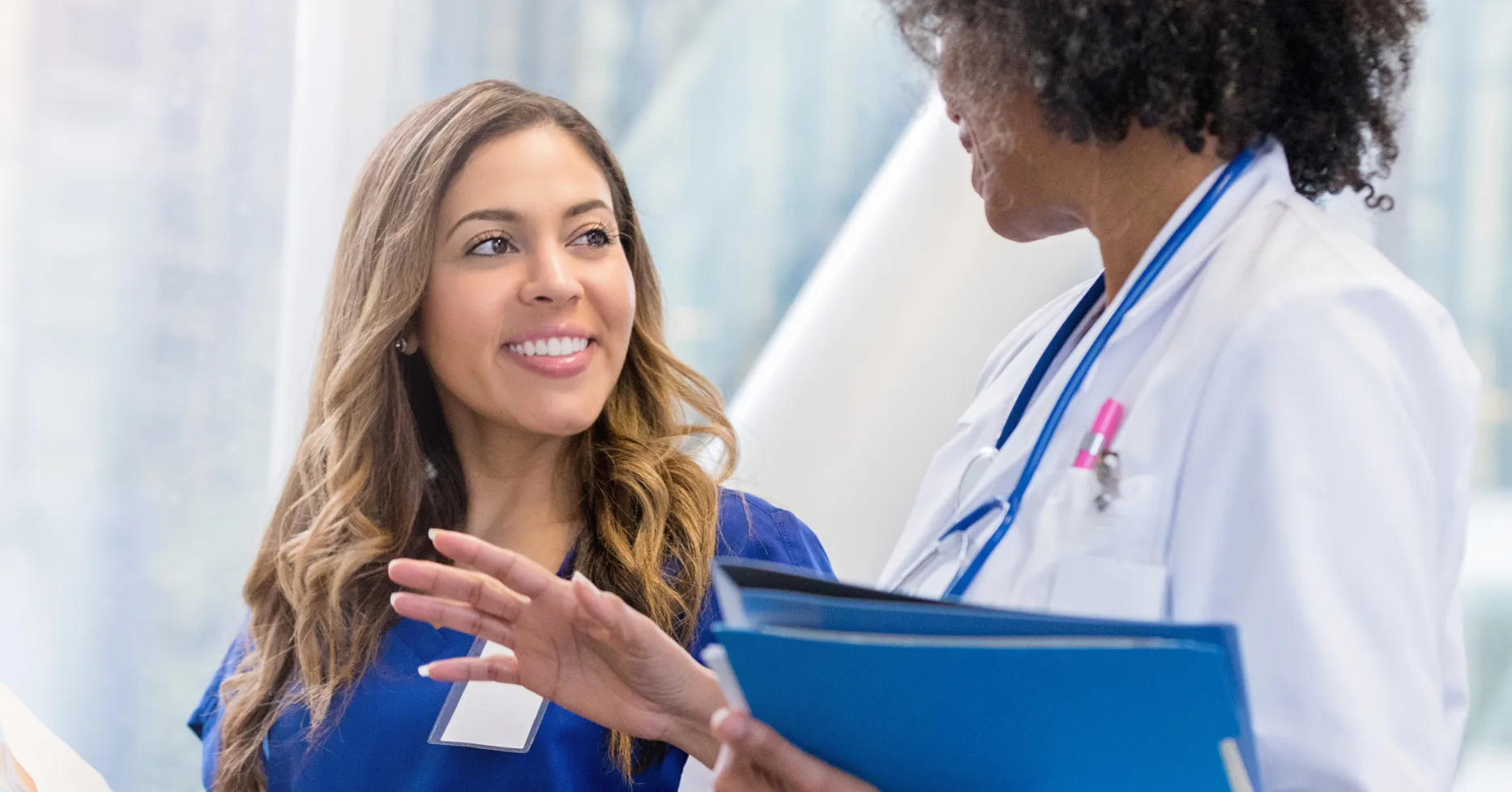 Smiling nurse getting instructions from doctor